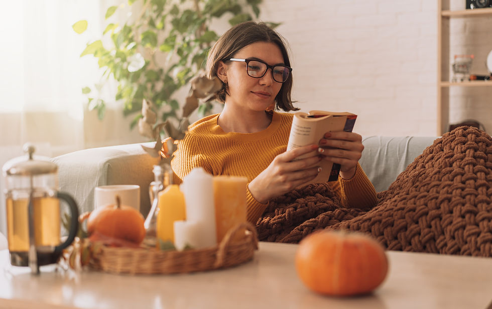 a person reading a book among fall decor