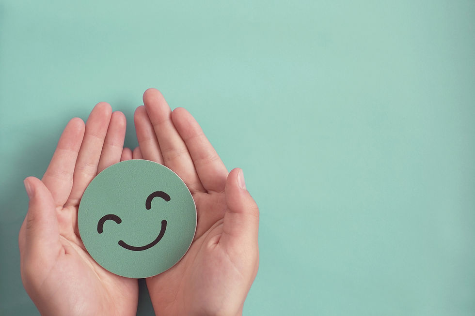 a pair of hands holding a cutout smiley face