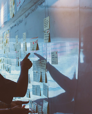 finger pointing to board with post-its