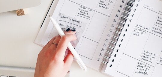 a hand writing in a notebook